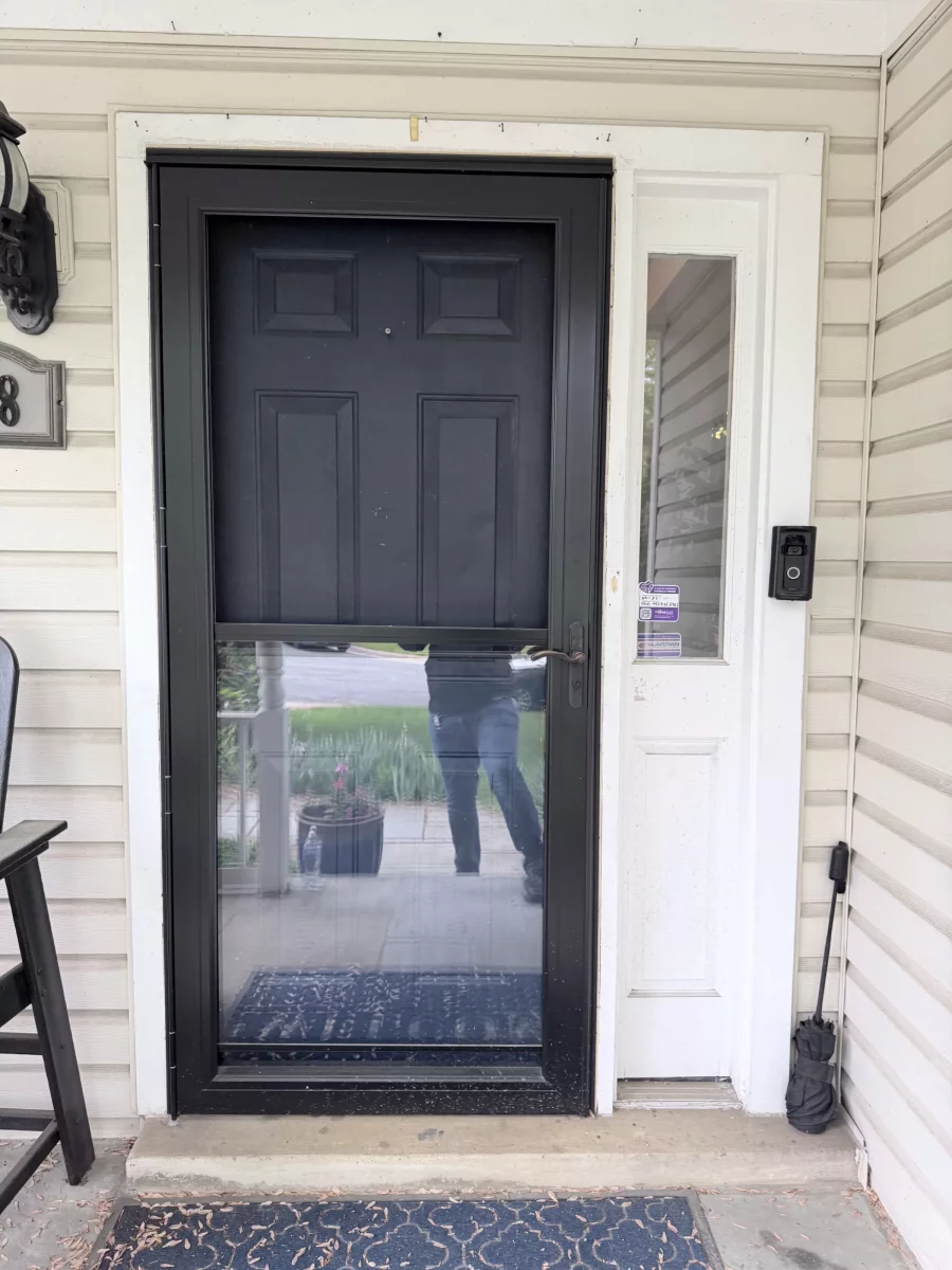 Black storm door installed on residential entry with side window