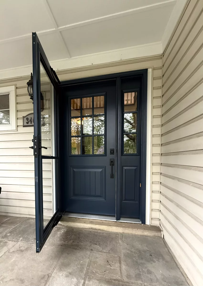 Blue entry door with glass panels and storm door on residential exterior