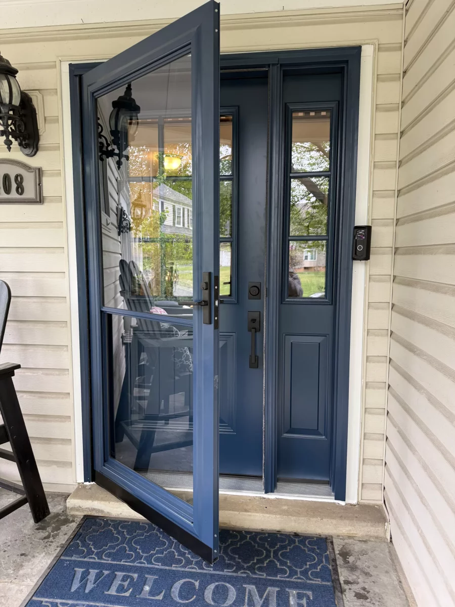 Blue storm door and entry door with glass panels on a residential porch