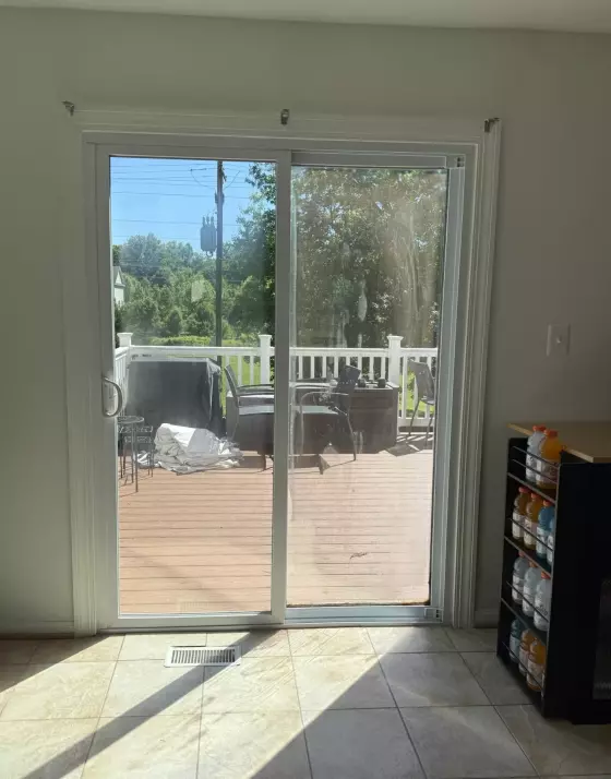 Sliding glass patio door with tile floor and outdoor deck visible
