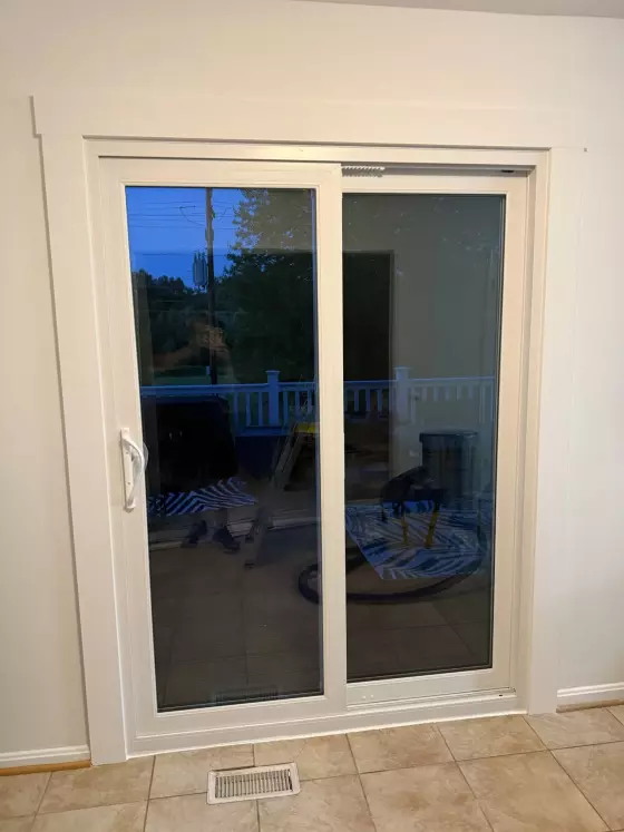 White sliding glass patio door with trim in tiled interior room