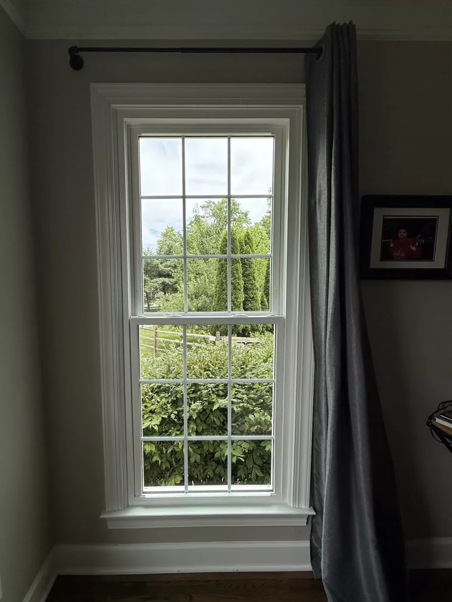 Energy-efficient double-hung window replacement in Rockville, MD, with grids and professionally finished interior trim.