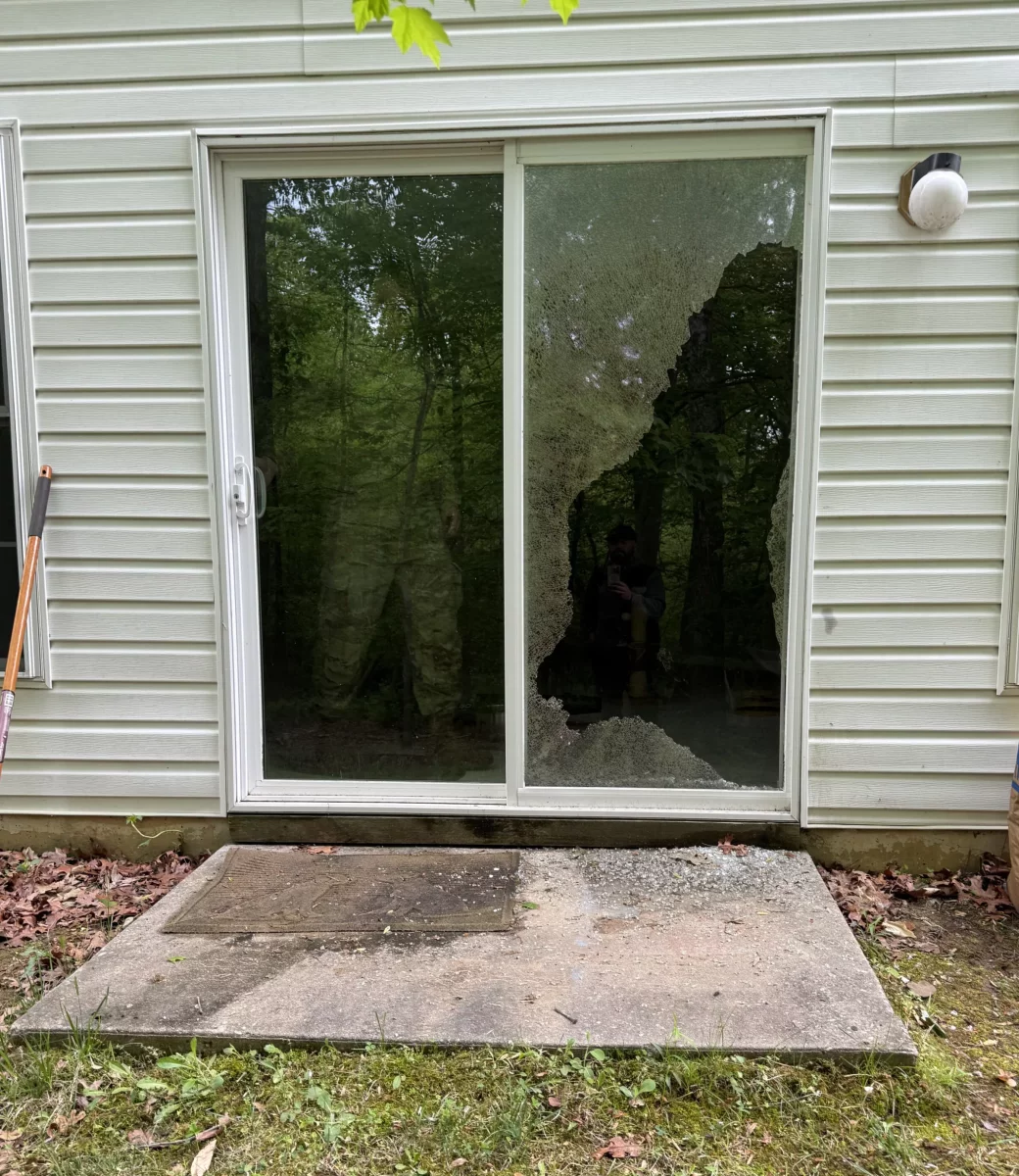 Shattered tempered glass on a sliding patio door before professional glass replacement in Aspen Hill, Maryland