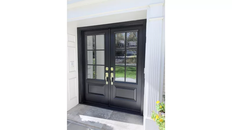 Black French front entry doors with SDL beveled grids and brass handles after a front door replacement.