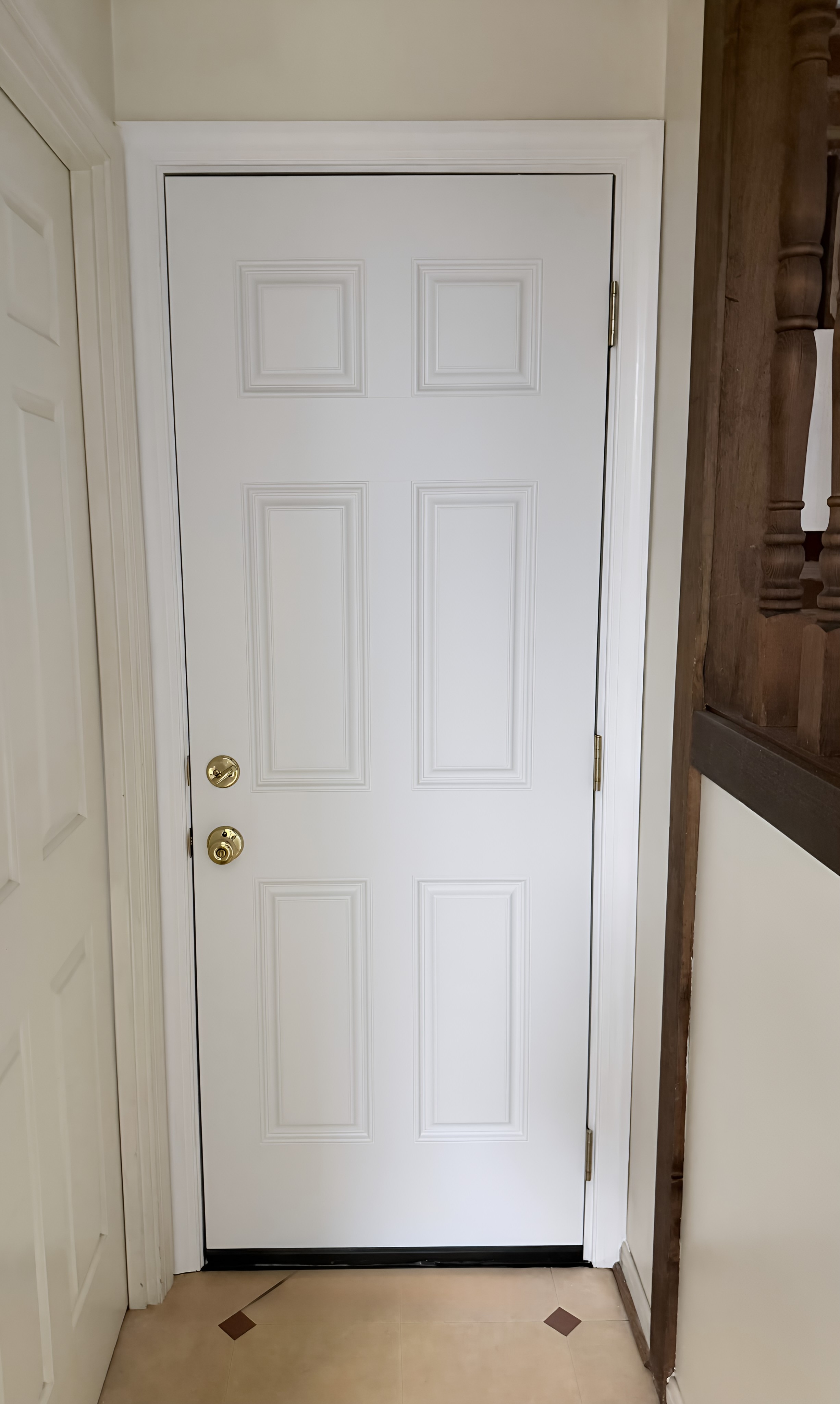 Completed door replacement with new six-panel white door and updated weatherstripping.