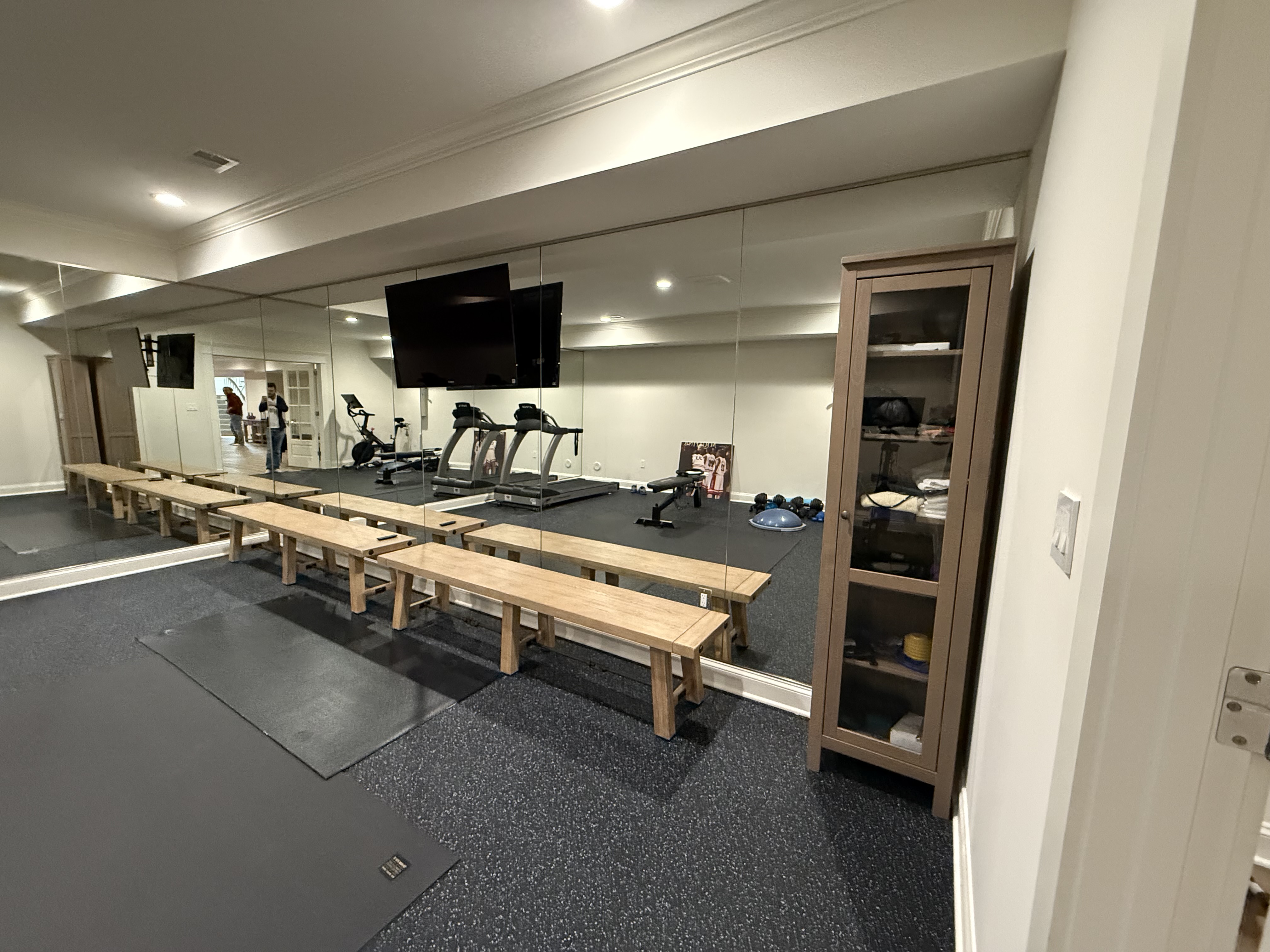Finished home gym with installed mirrors creating bright and open workout space in Bethesda.
