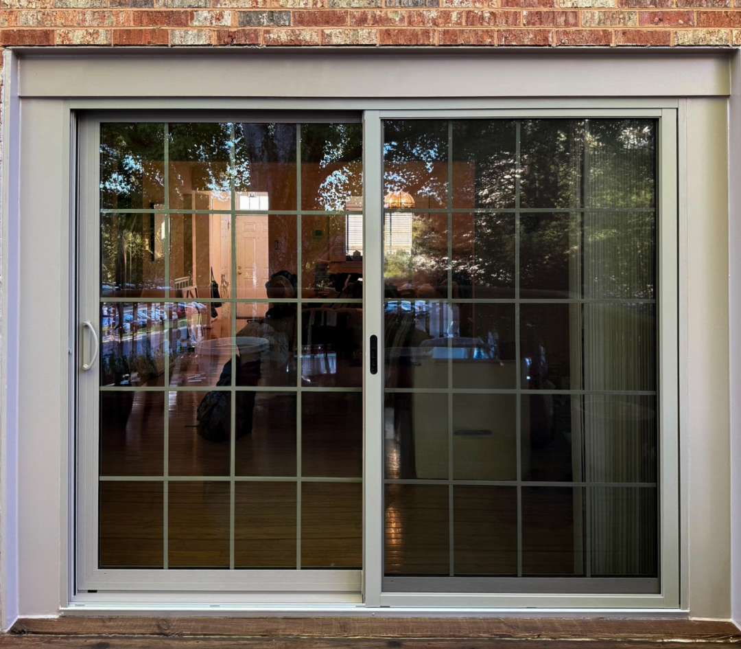 Exterior view of newly installed sliding patio door with reflective double-pane glass.
