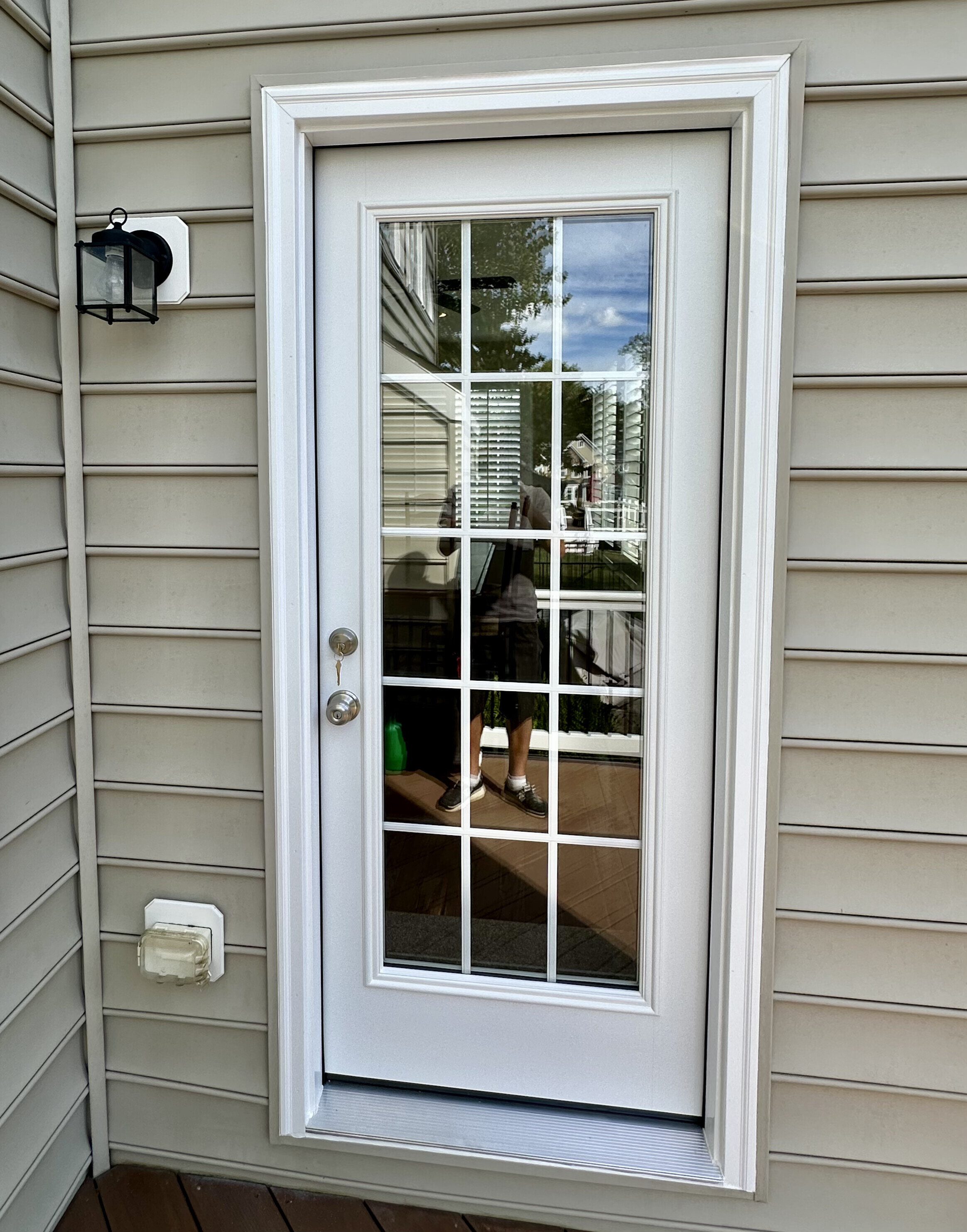 White exterior door with glass panels and trim on residential siding