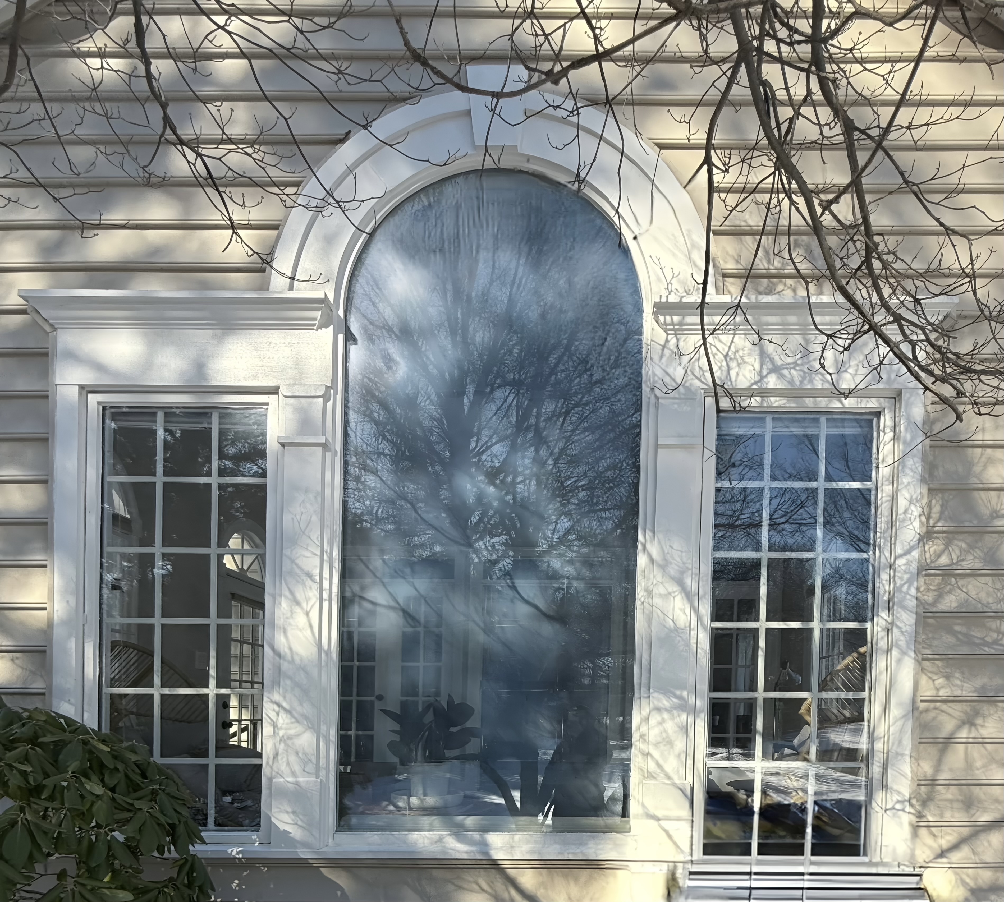 Exterior view showing foggy arched window before replacement due to failed seal.