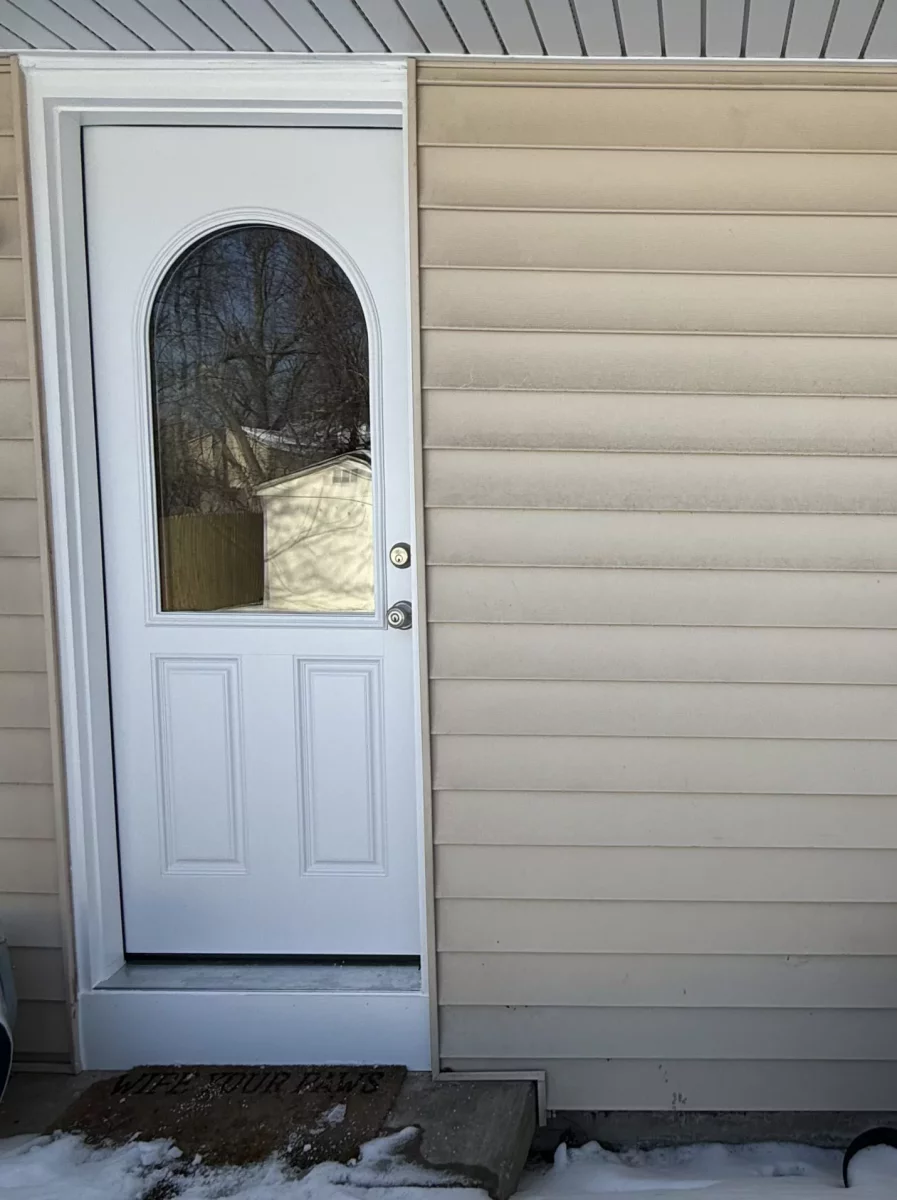 Exterior view of a house with a white door and window in winter