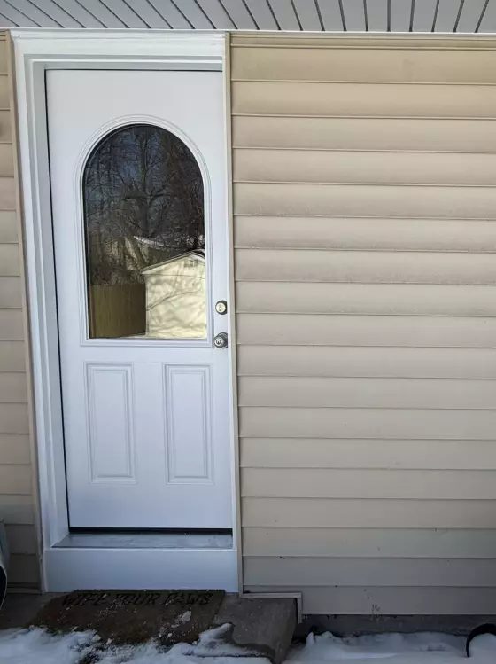 Exterior view of a house with a white door and window in winter
