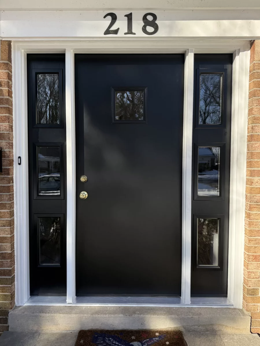 Black entry door with sidelights and brick exterior