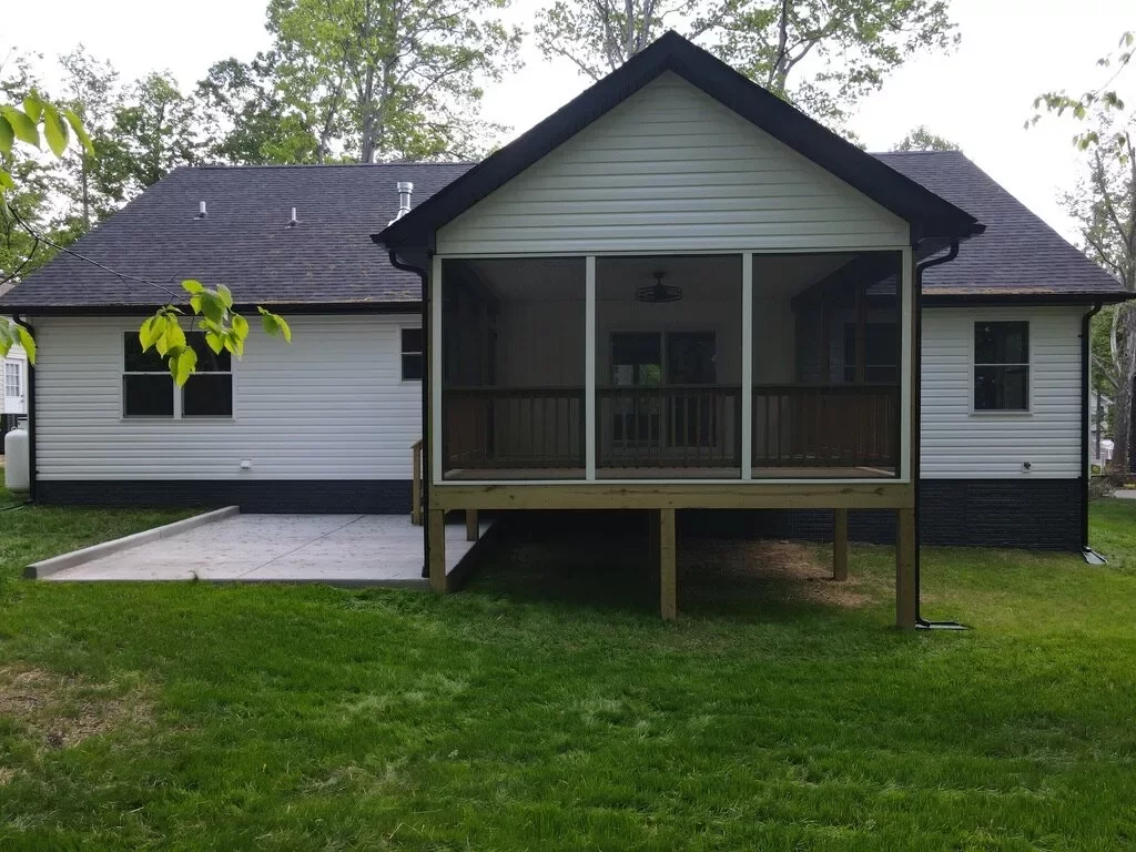 Custom home with a black screened-in porch and white board-and-batten siding