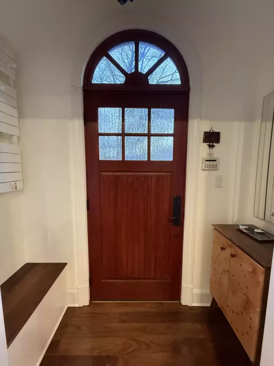 Wood entry door with glass panels and trim in residential interior