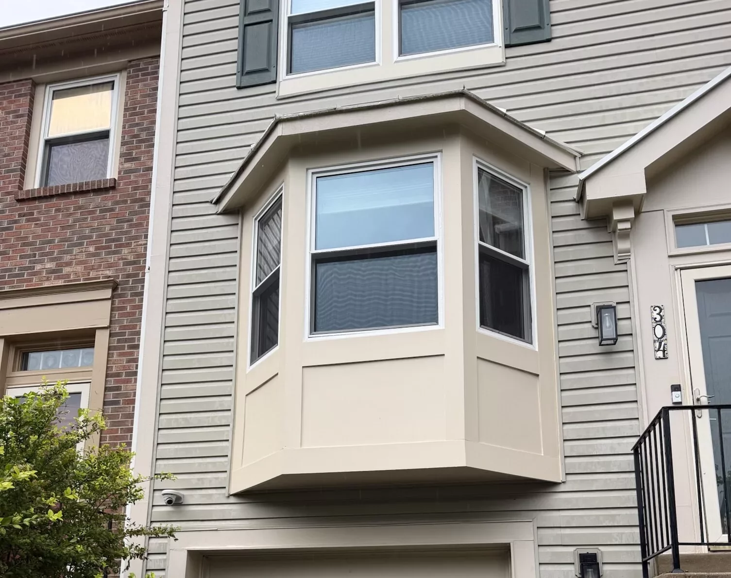Residential townhouse exterior with bay window and garage door
