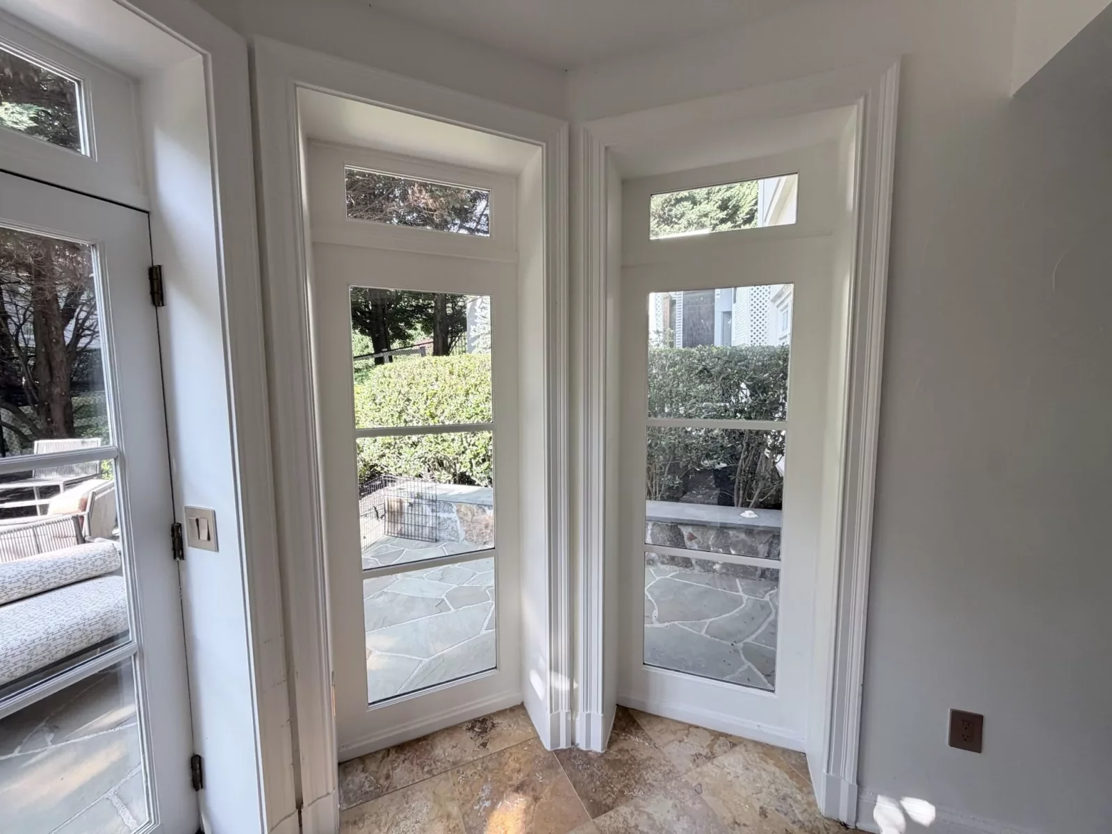 Interior view of two glass doors with white trim and stone floor