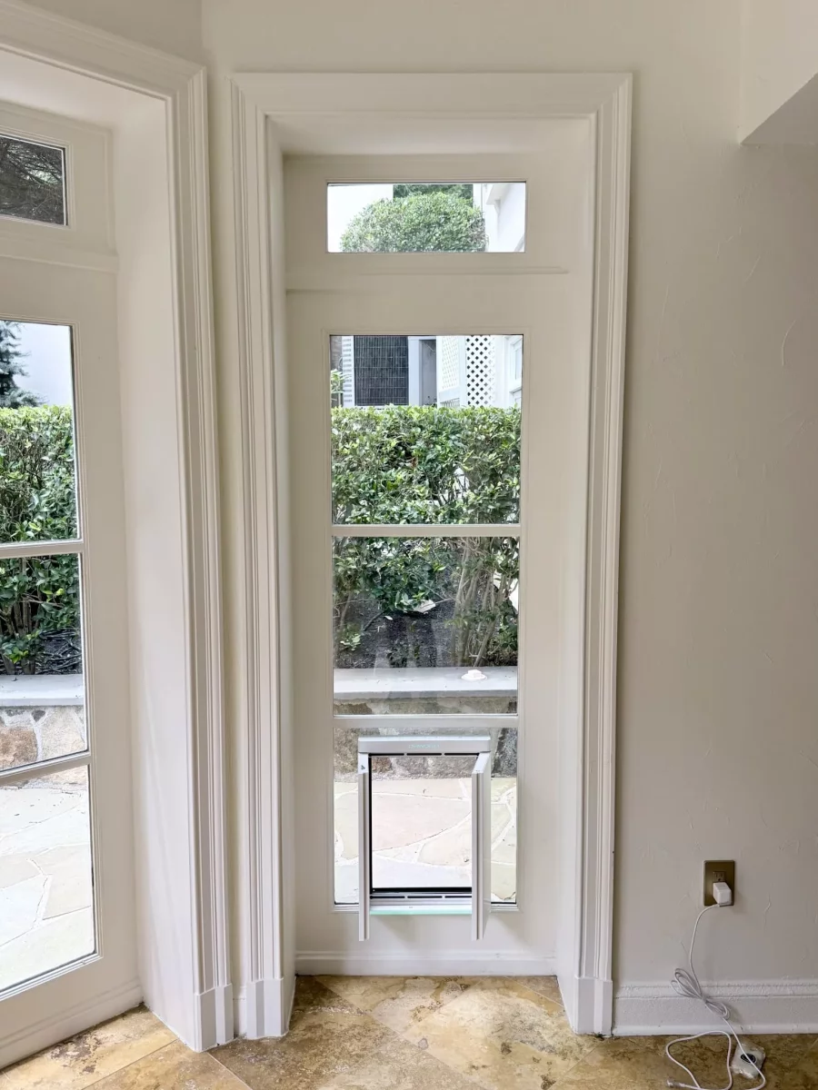 Interior window with installed pet door and tile floor