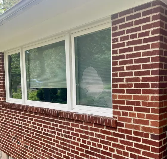 Exterior view of brick wall with window showing broken glass