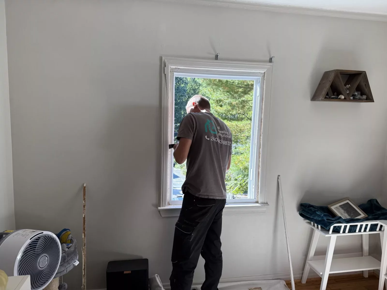 Person working on window installation inside a residential room