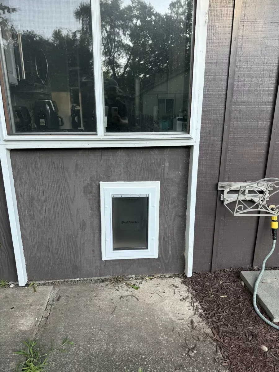Completed exterior pet door installation below window