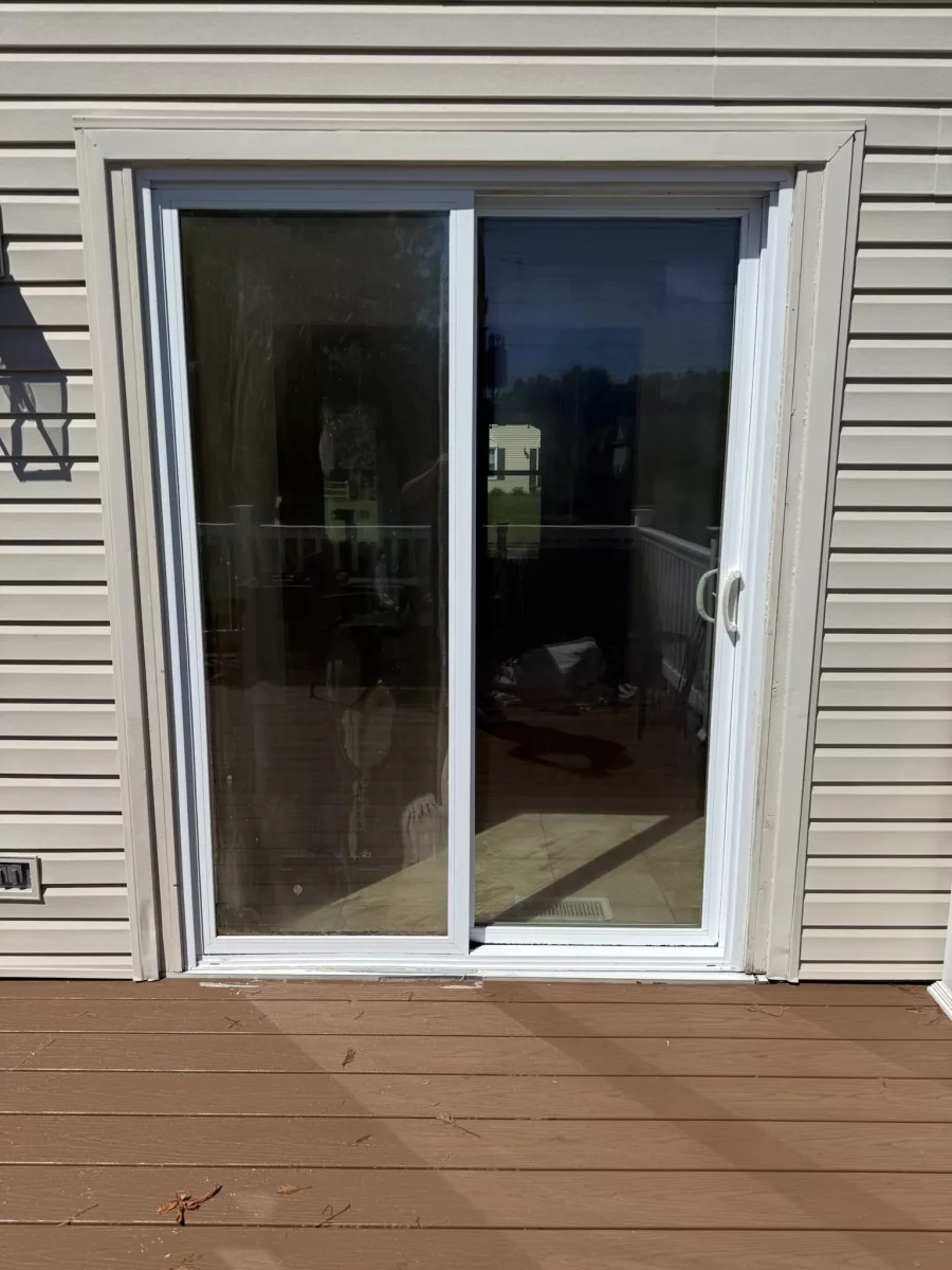Old foggy sliding glass patio door before residential door replacement