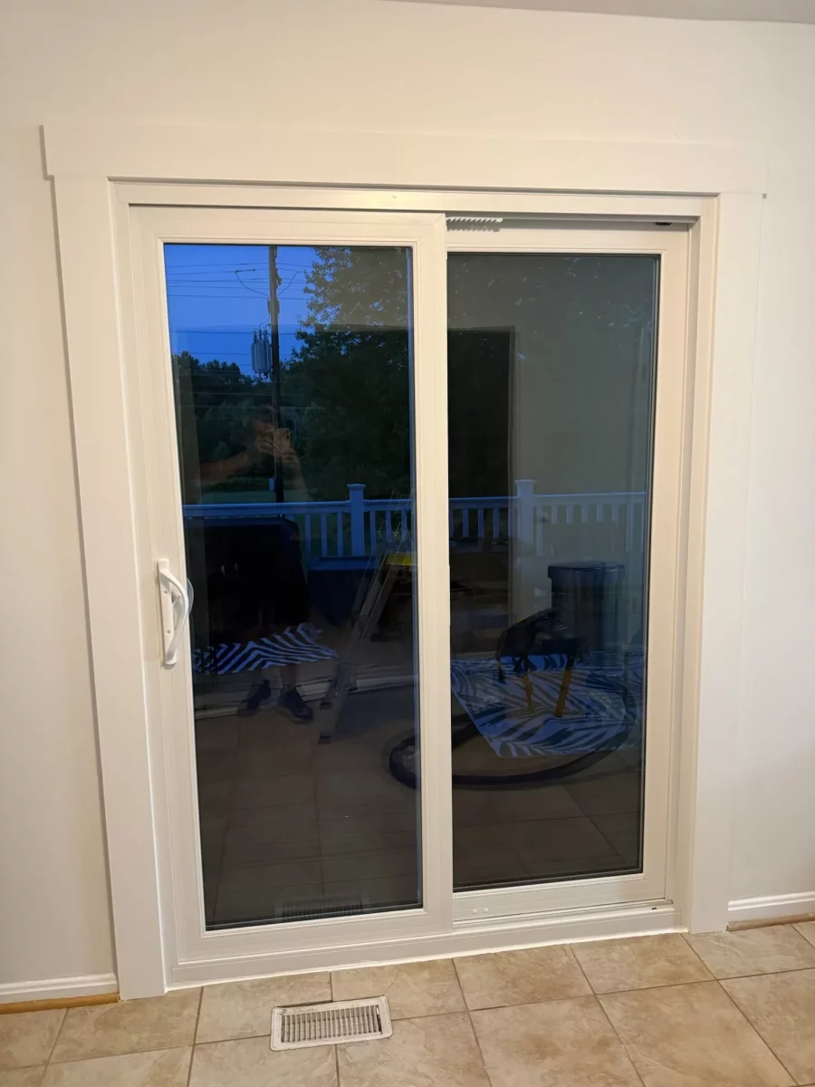 White sliding glass patio door with trim in tiled interior room