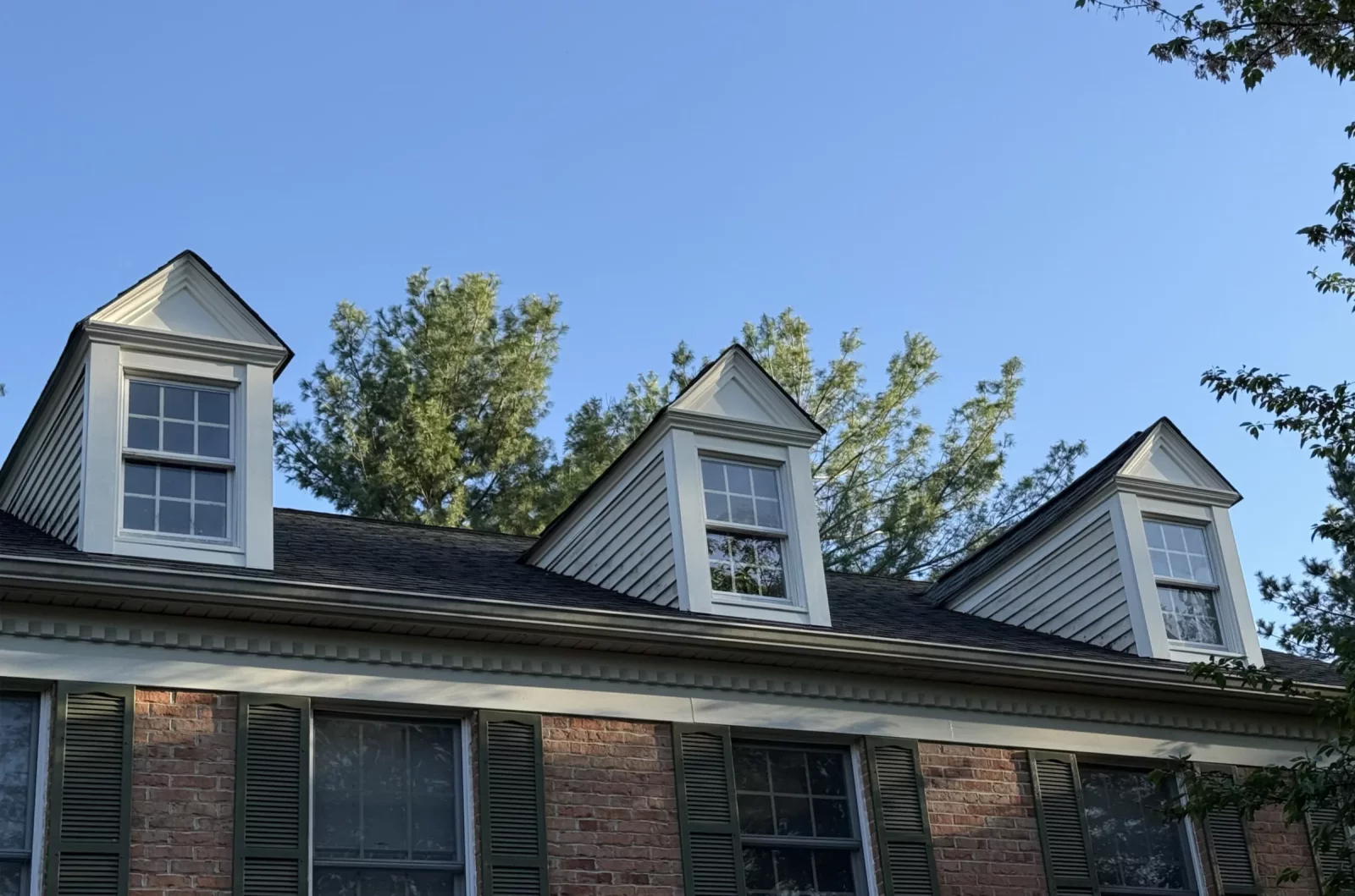 Exterior view of house roof with three dormer windows