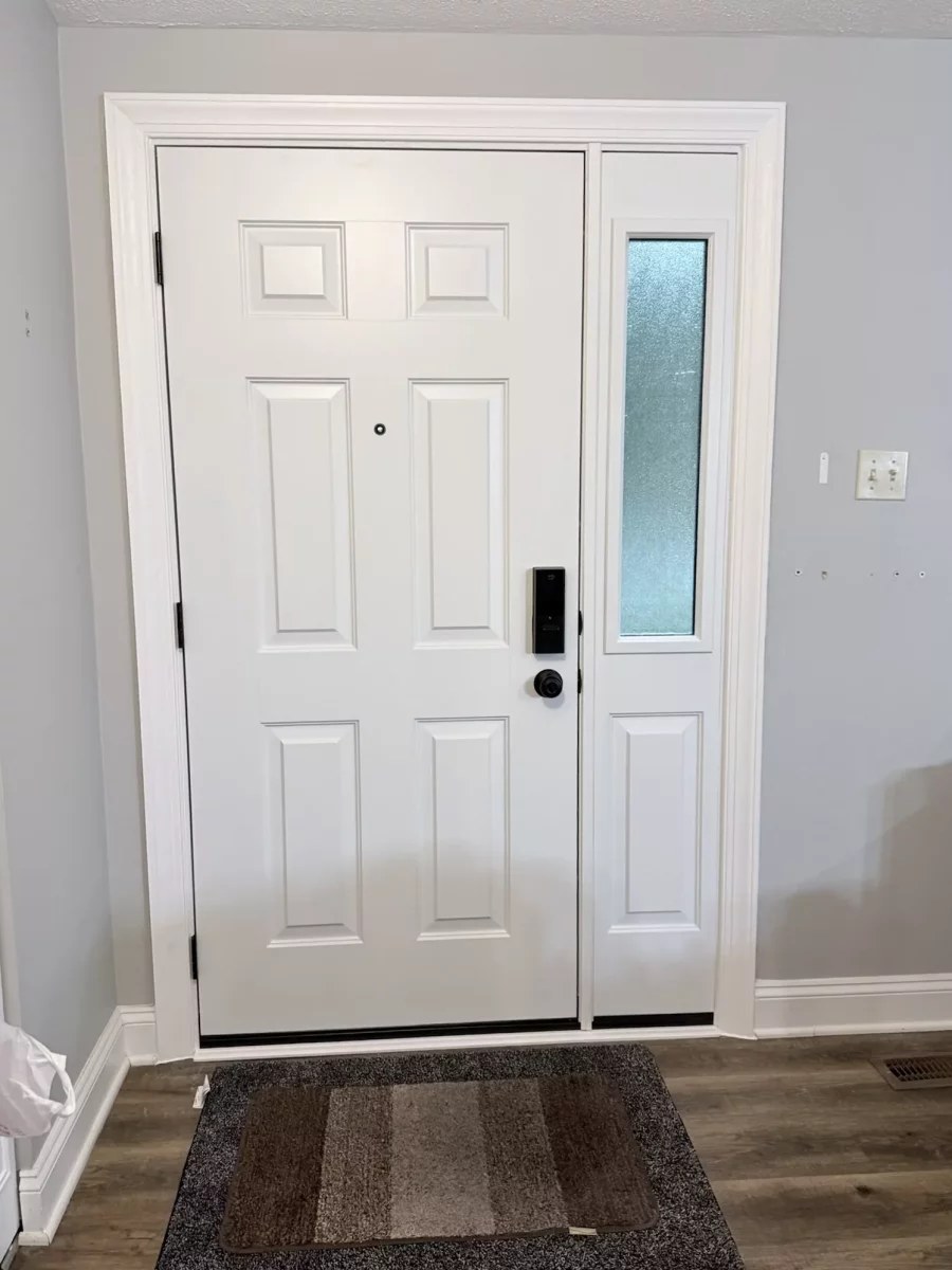White entry door with side window and trim inside a home