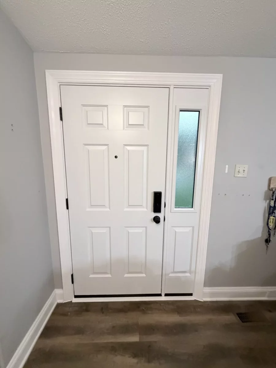 White entry door with glass sidelight and trim viewed from inside