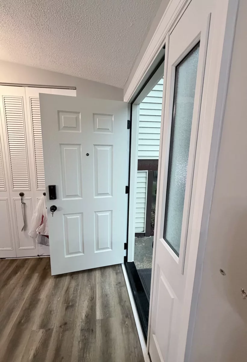 White entry door with glass panel installed in residential interior