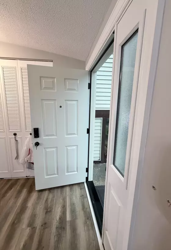 White entry door with glass panel installed in residential interior