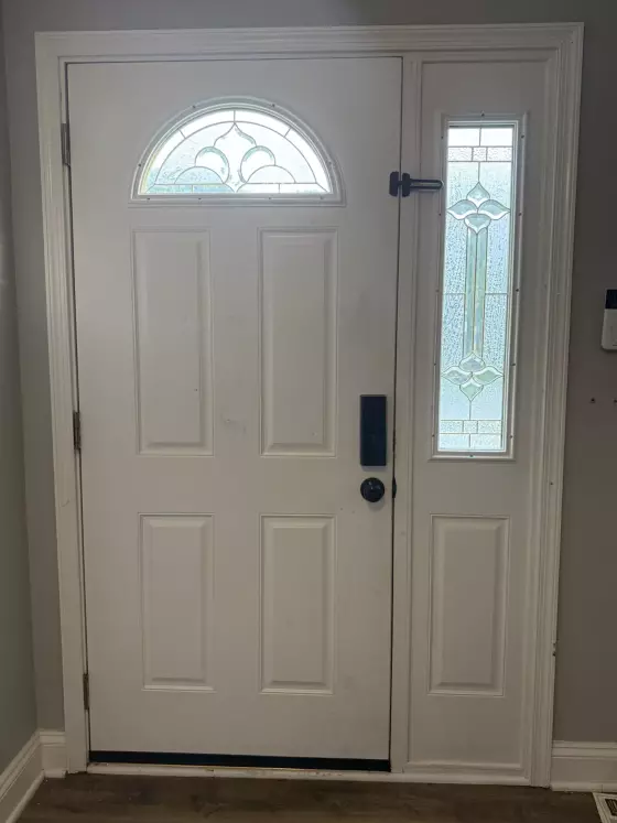 Before: Original front entry door and decorative glass sidelight prior to replacement in Columbia, MD.
