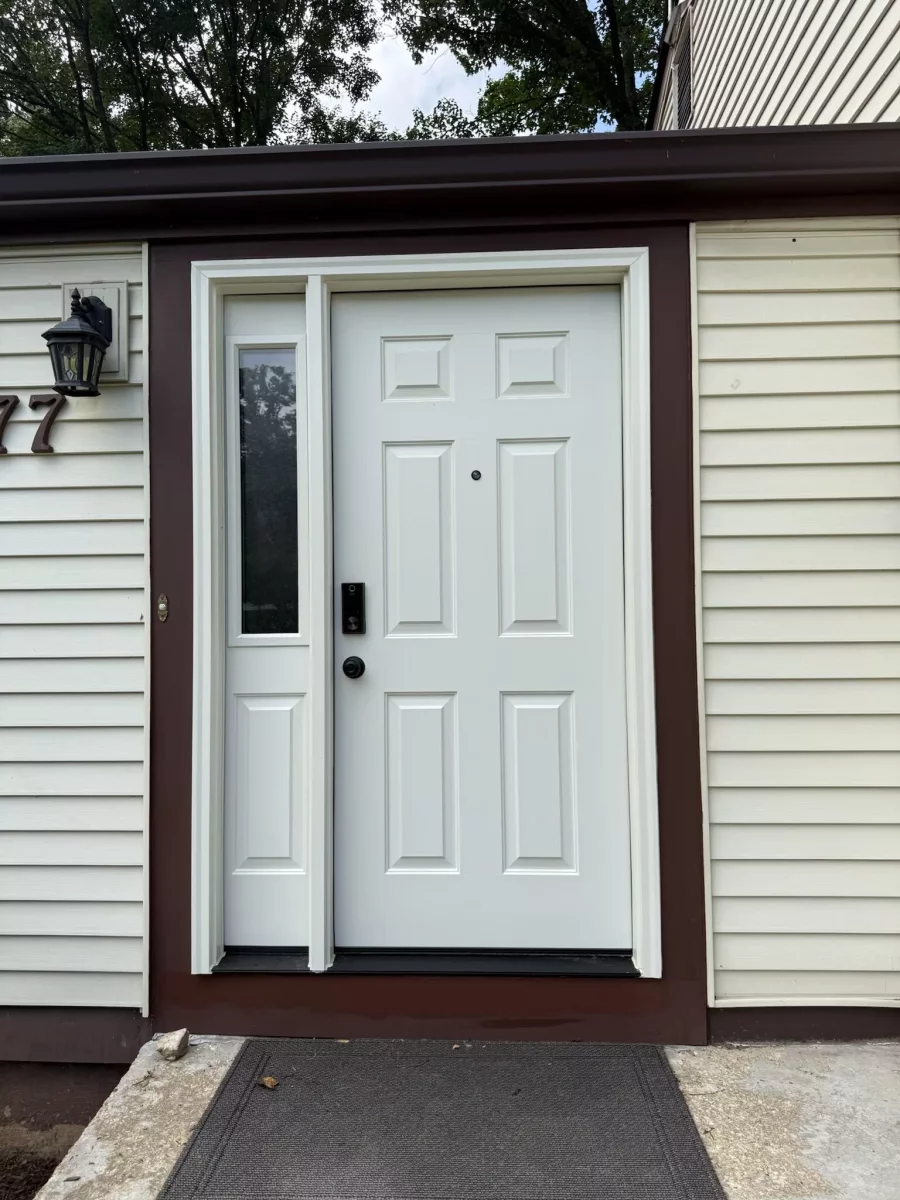 White entry door with side window and brown trim on residential exterior