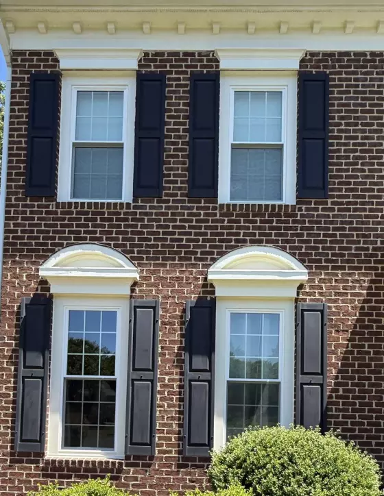 Before four window replacements, showing the original double-hung windows on a brick home in Rockville, Maryland.