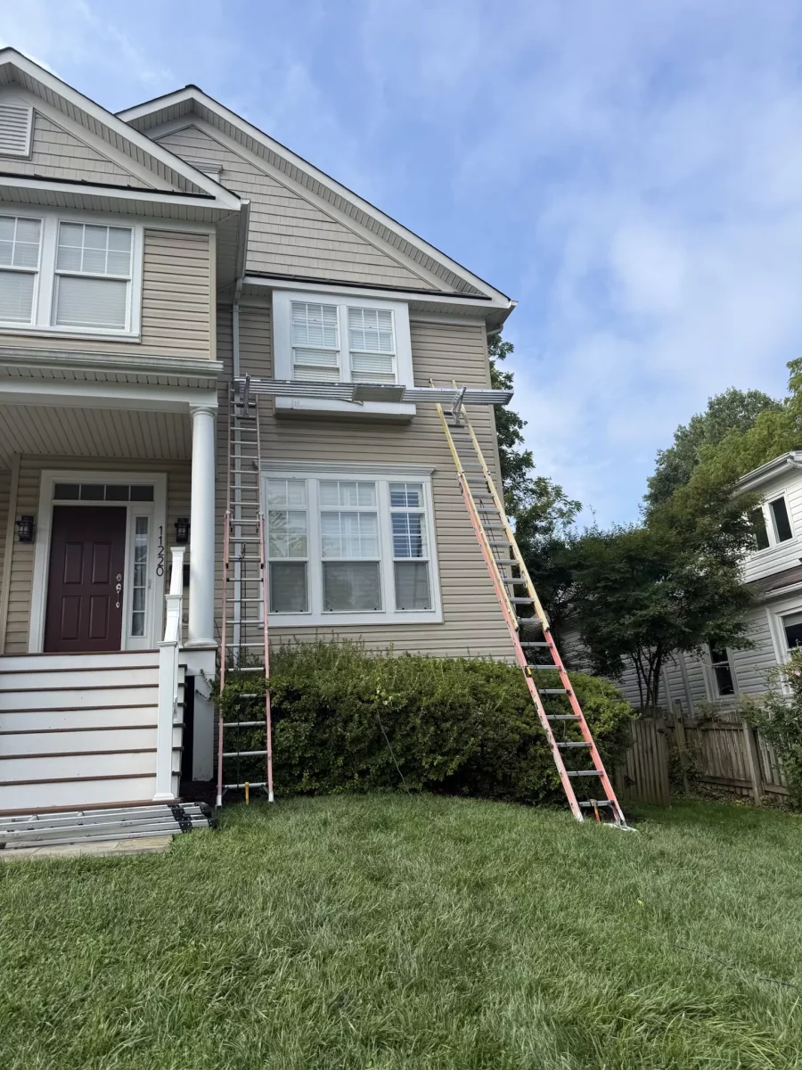 Ladders set up against house facade for window work
