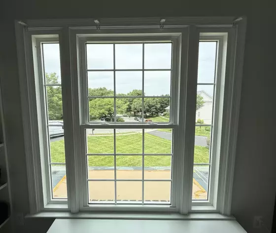 Completed energy-efficient window replacement in Rockville, MD, featuring a double-hung window with grids and two sidelites.