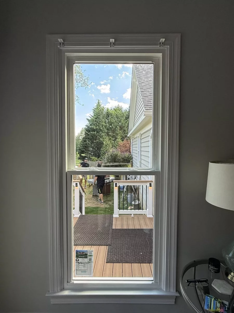 Completed energy-efficient window replacement in Rockville, MD, featuring a double-hung window with grids and two sidelites.