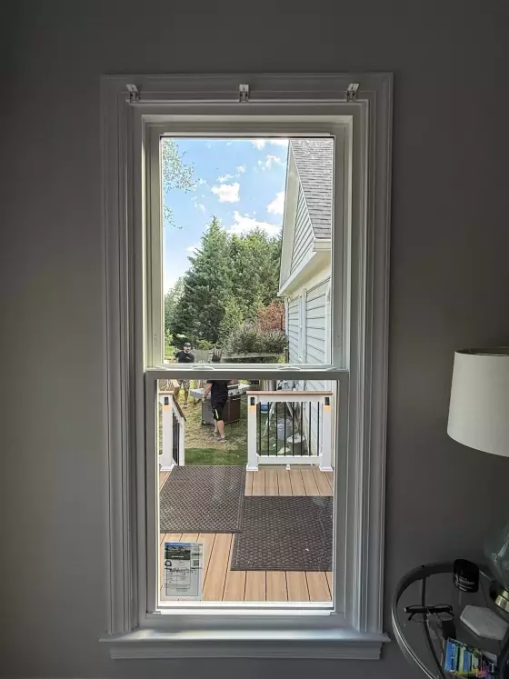 Completed energy-efficient window replacement in Rockville, MD, featuring a double-hung window with grids and two sidelites.