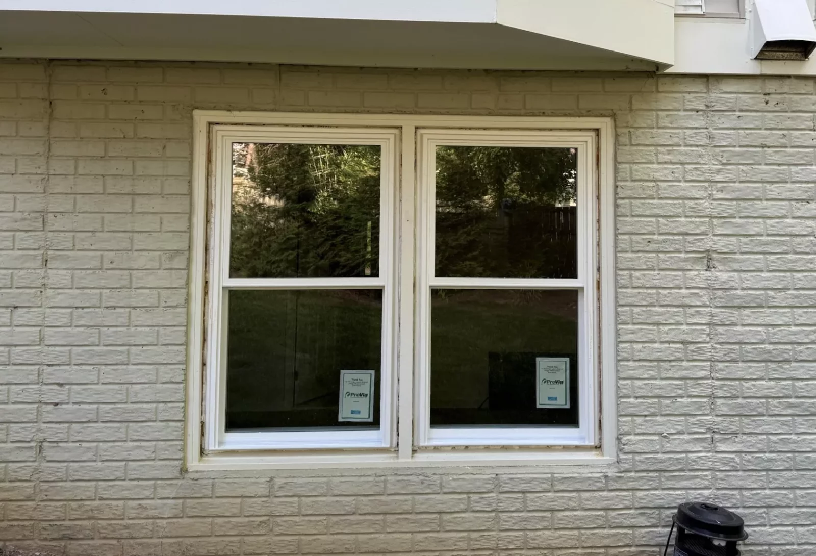 Completed exterior window replacement in Rockville, MD, featuring two energy-efficient double-hung windows in a brick wall.