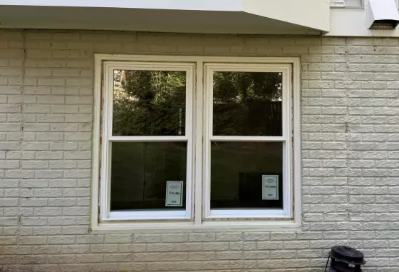 Completed exterior window replacement in Rockville, MD, featuring two energy-efficient double-hung windows in a brick wall.