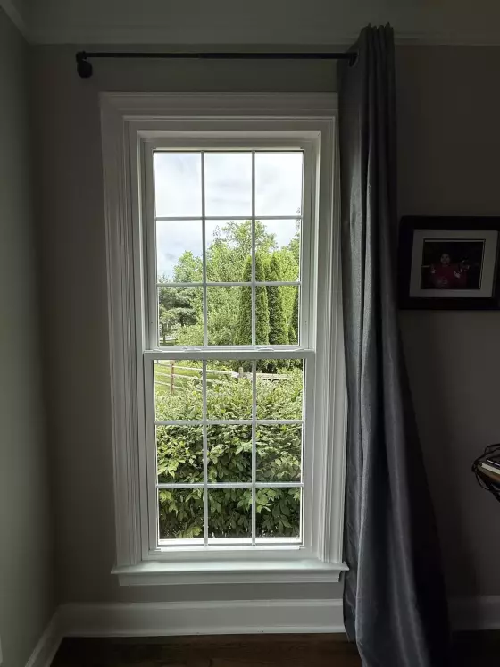 Energy-efficient double-hung window replacement in Rockville, MD, with grids and professionally finished interior trim.