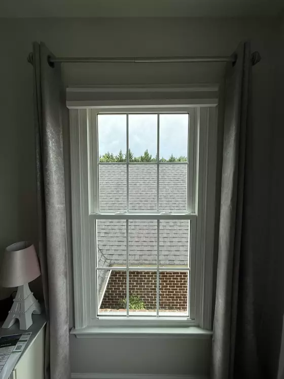 Energy-efficient double-hung window replacement in Rockville, MD, with grids and professionally finished interior trim.