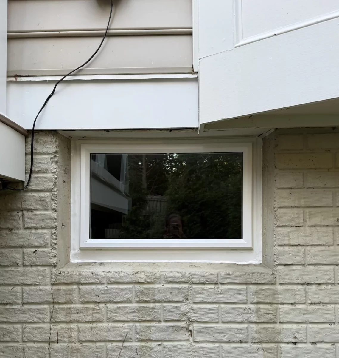 Completed basement picture window replacement with clean white trim and weather-sealed installation in Rockville, MD.