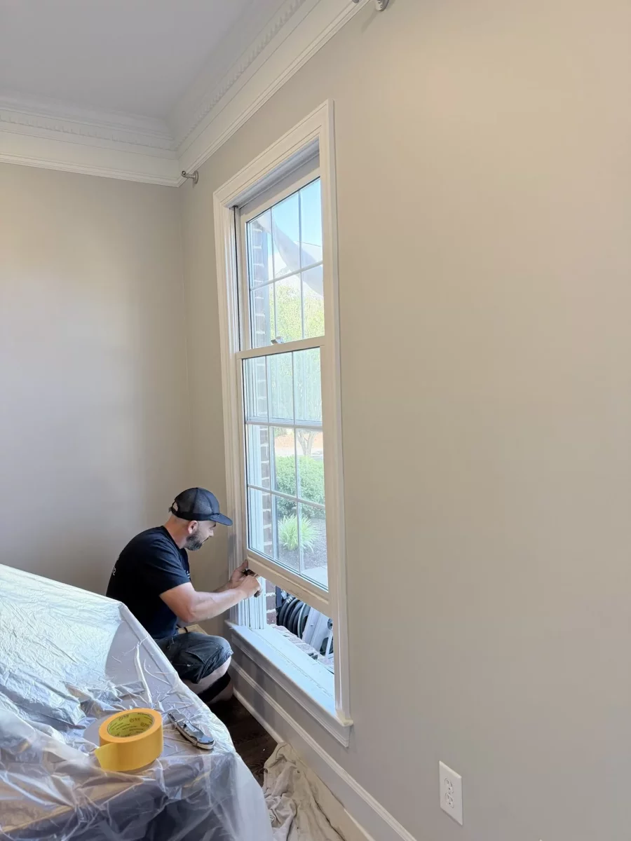 Worker installing window in residential interior room