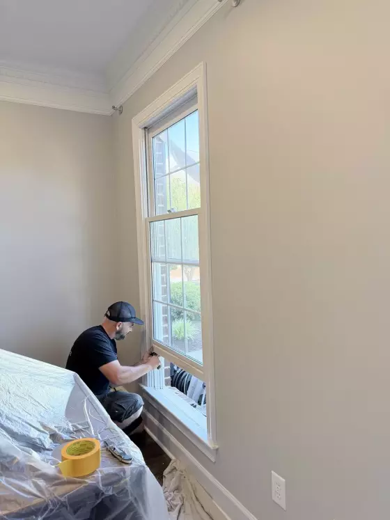 Worker installing window in residential interior room
