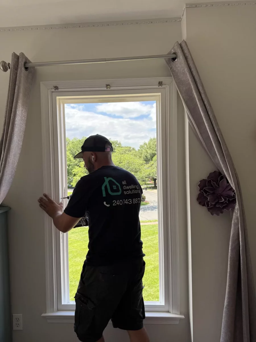 Person installing a window inside a residential room