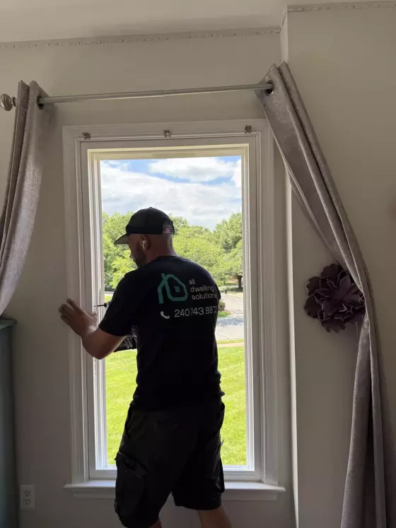 Person installing a window inside a residential room