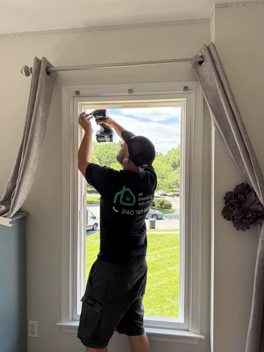 Person installing a window inside a residential room