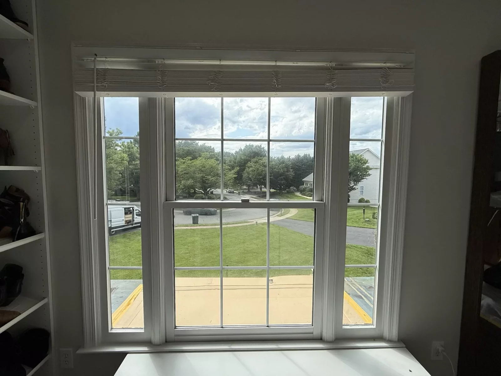 Interior view of a double-hung window with white trim and blinds