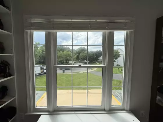 Interior view of a double-hung window with white trim and blinds